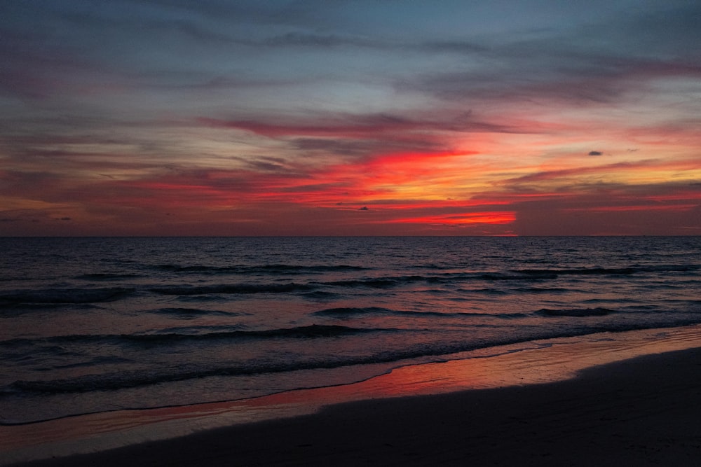 sea waves crashing on shore during sunset