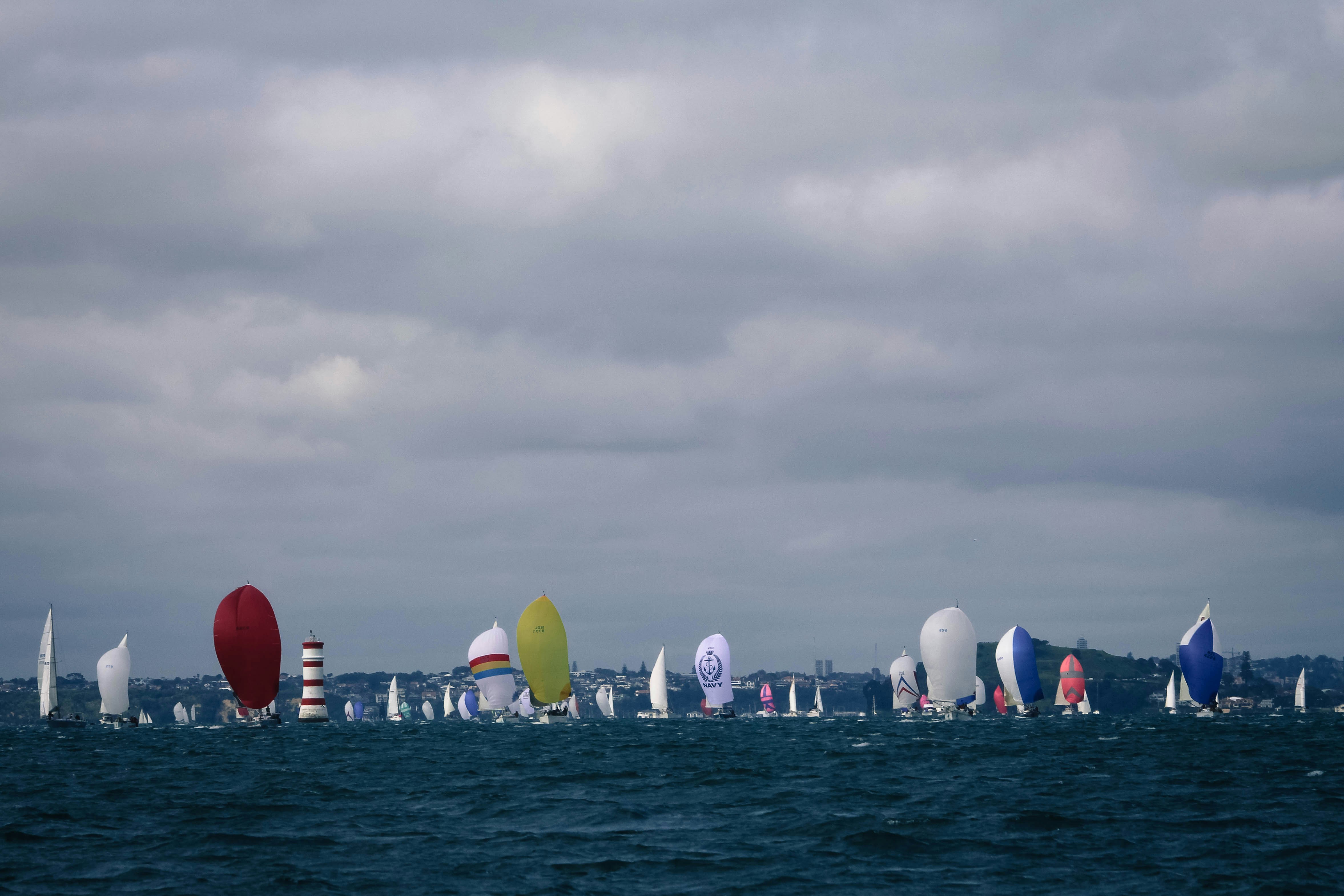 white and red boats on sea under white clouds during daytime