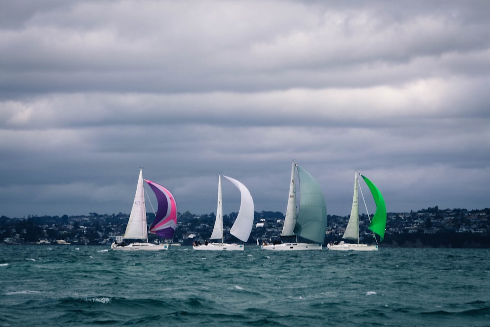 white sail boat on sea under cloudy sky during daytime