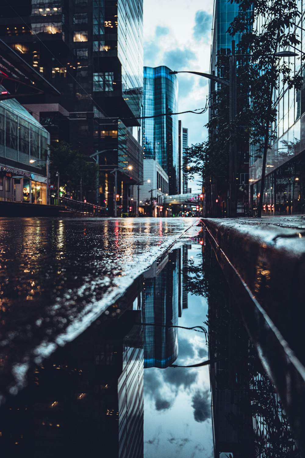 water on road between buildings during daytime