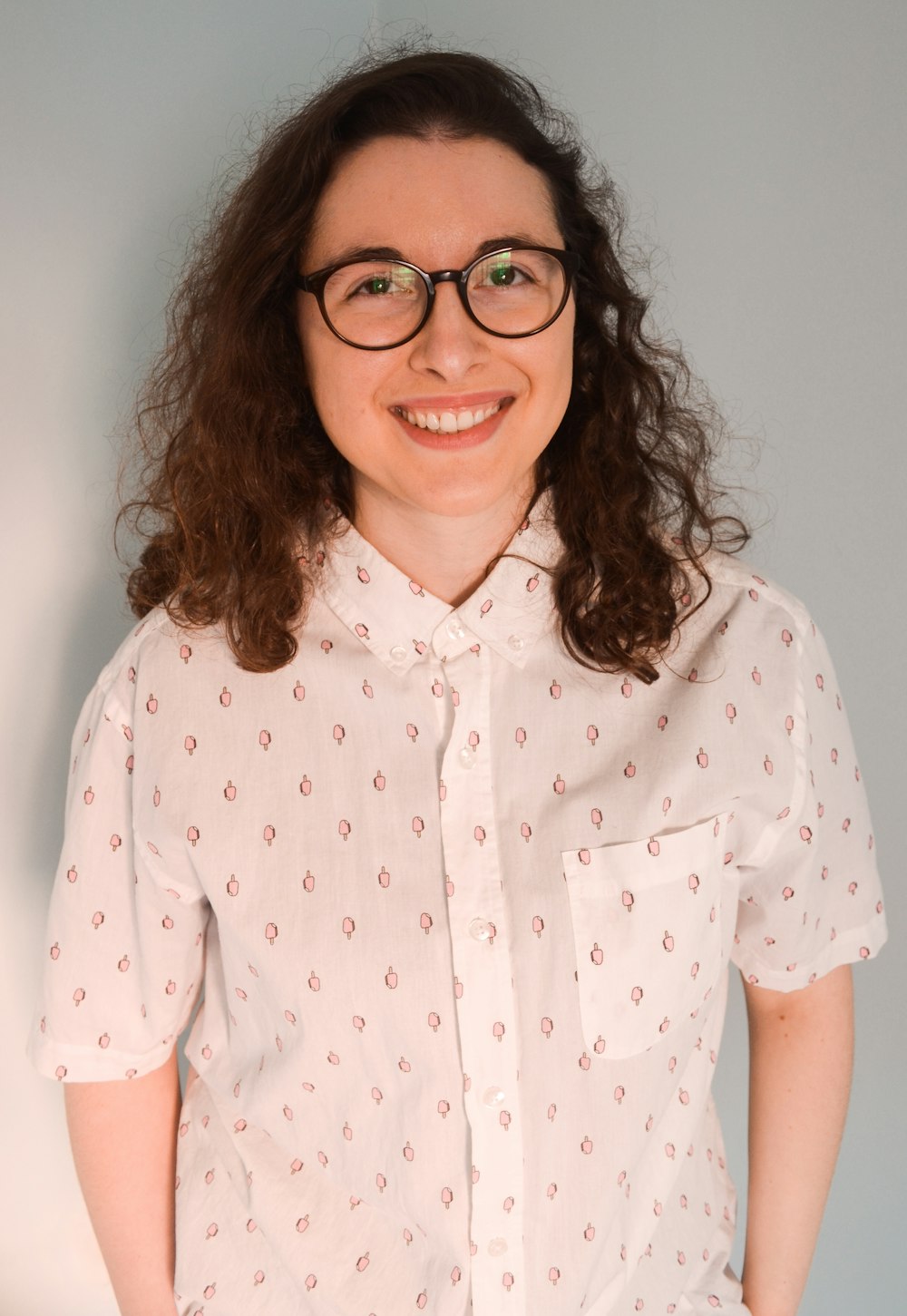 woman in white and red floral button up shirt wearing black framed eyeglasses