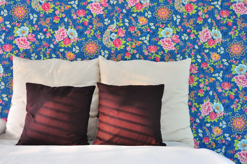 brown throw pillow on blue and red floral bed linen
