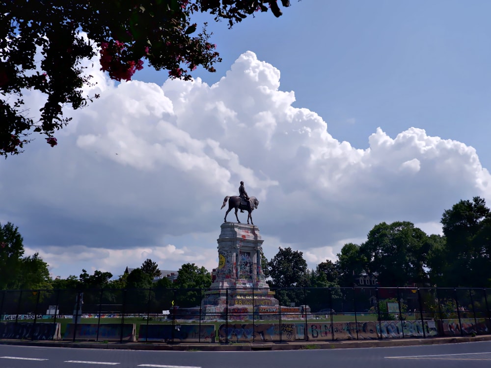 black statue under white clouds during daytime