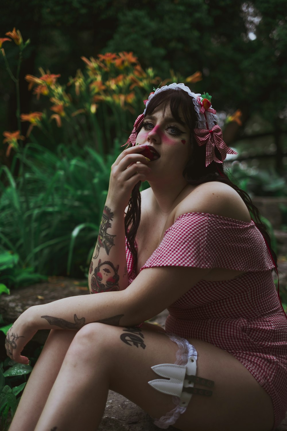 woman in red and white polka dot dress sitting on ground