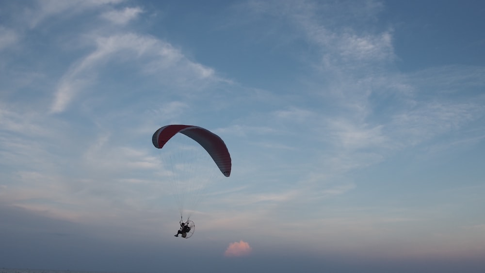 person in parachute under blue sky during daytime