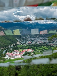 houses on green grass field near mountain under white clouds during daytime