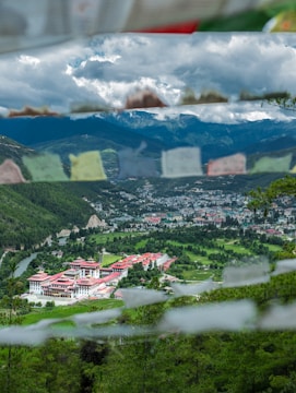 houses on green grass field near mountain under white clouds during daytime