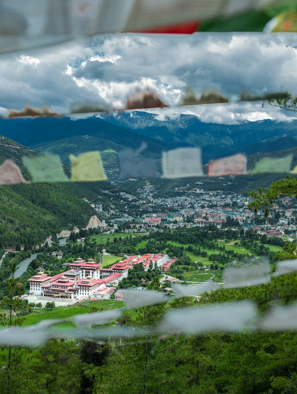 houses on green grass field near mountain under white clouds during daytime