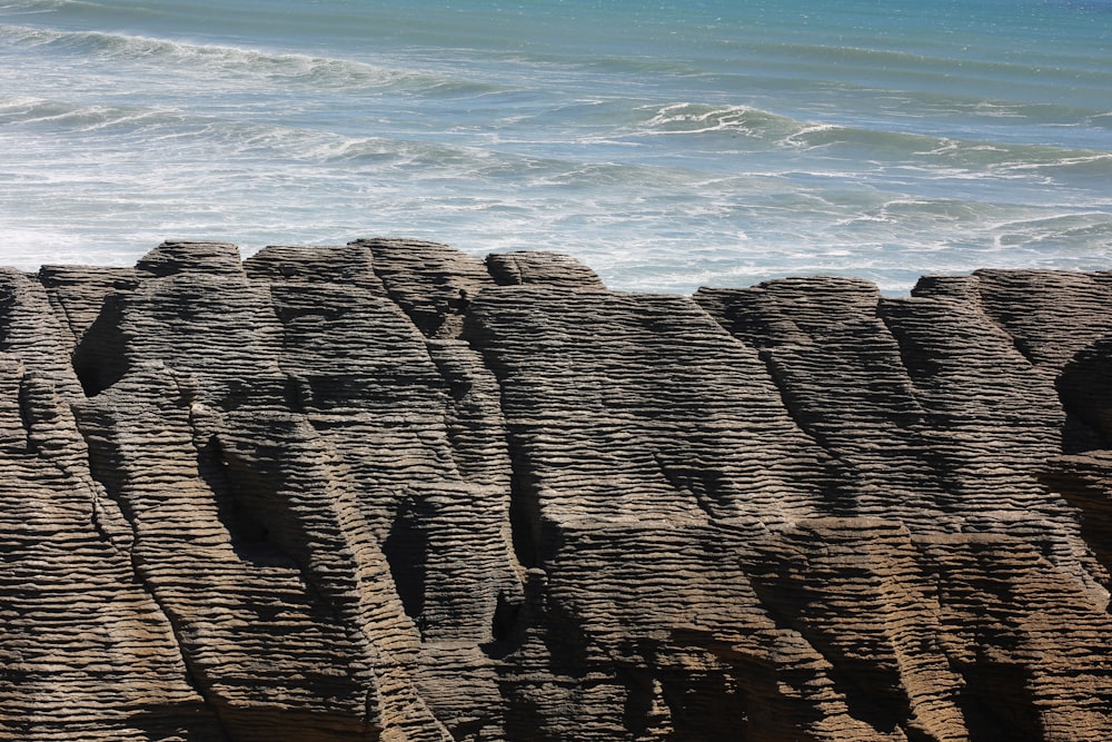 brown rocky mountain near sea during daytime