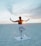 A serene yoga session on a beach at sunset, with participants in various poses.