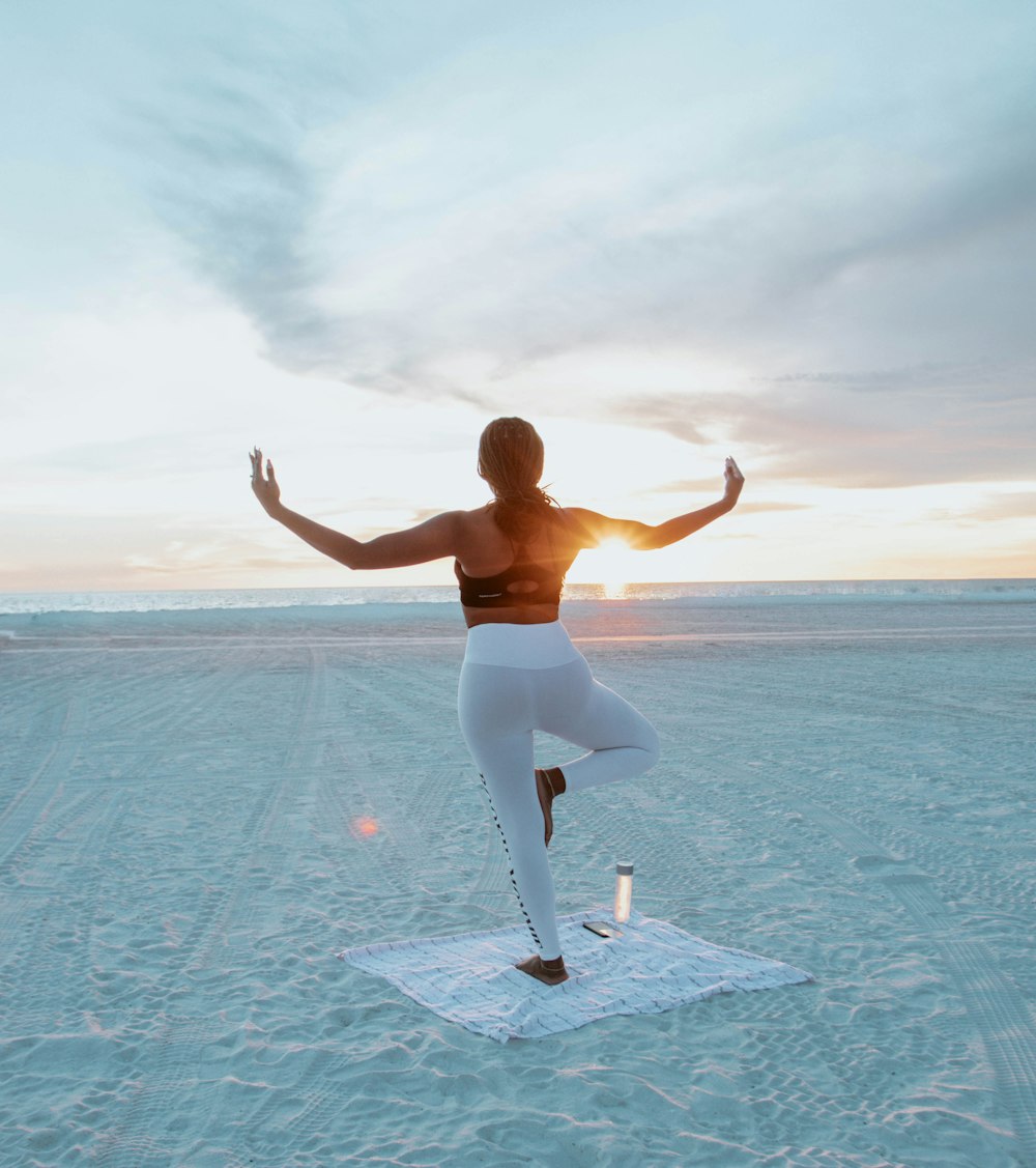 woman in white pants jumping on blue water during daytime