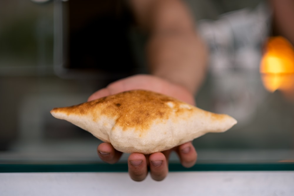 person holding bread on white table