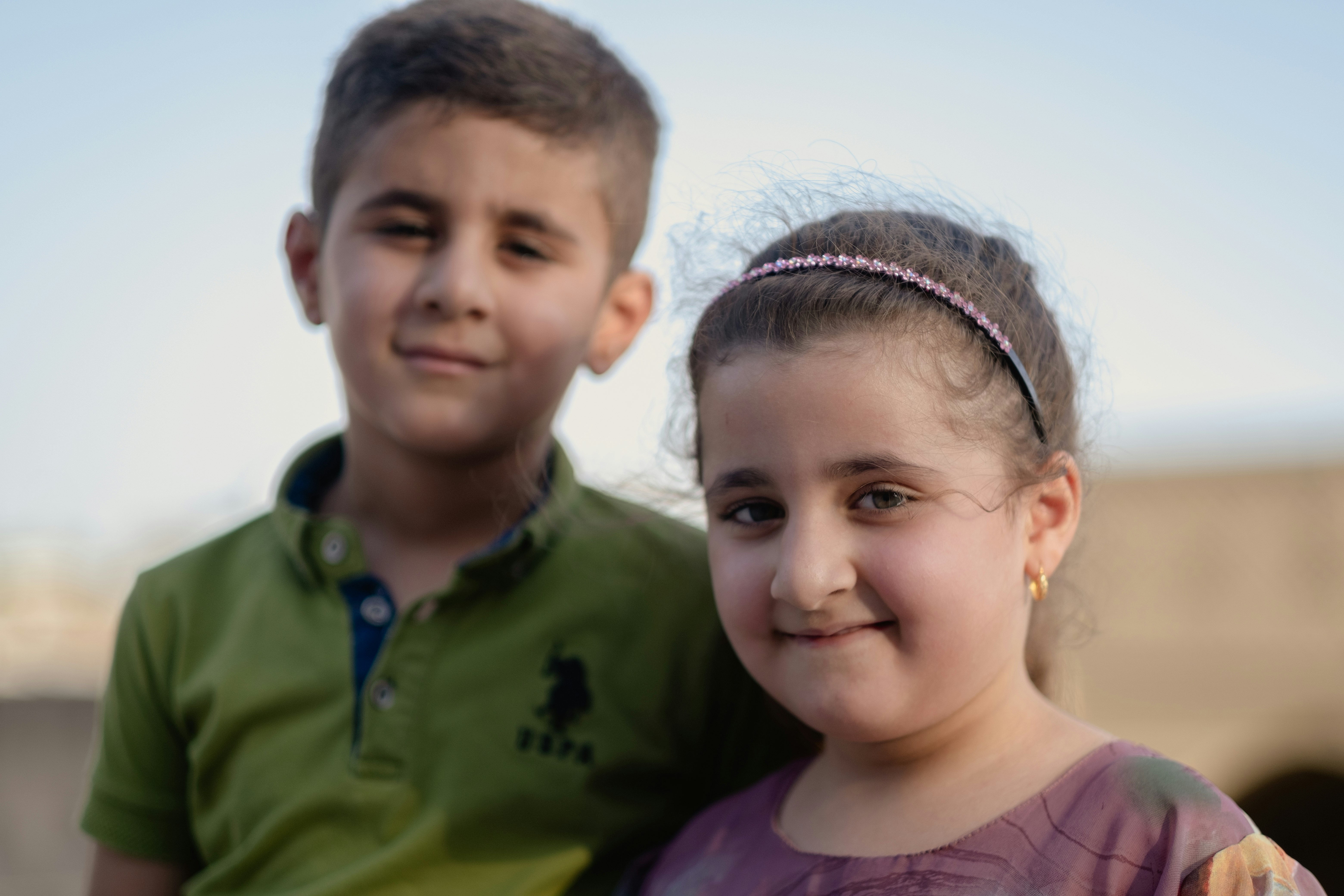 boy in green polo shirt beside girl in purple crew neck shirt