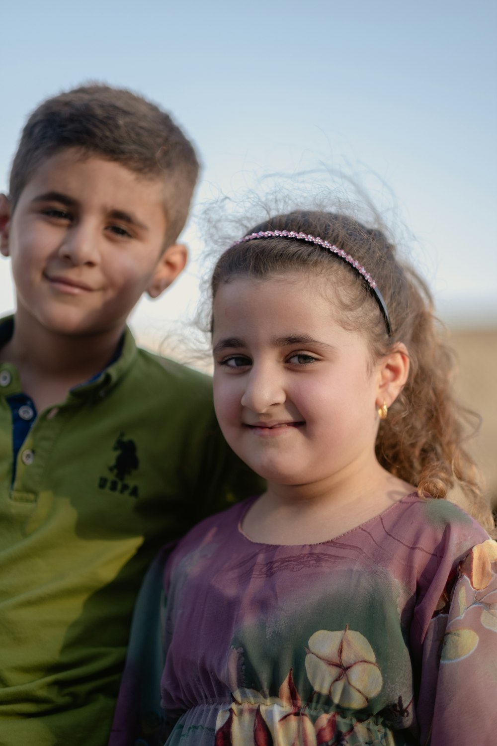 boy in green crew neck shirt beside girl in purple crew neck shirt