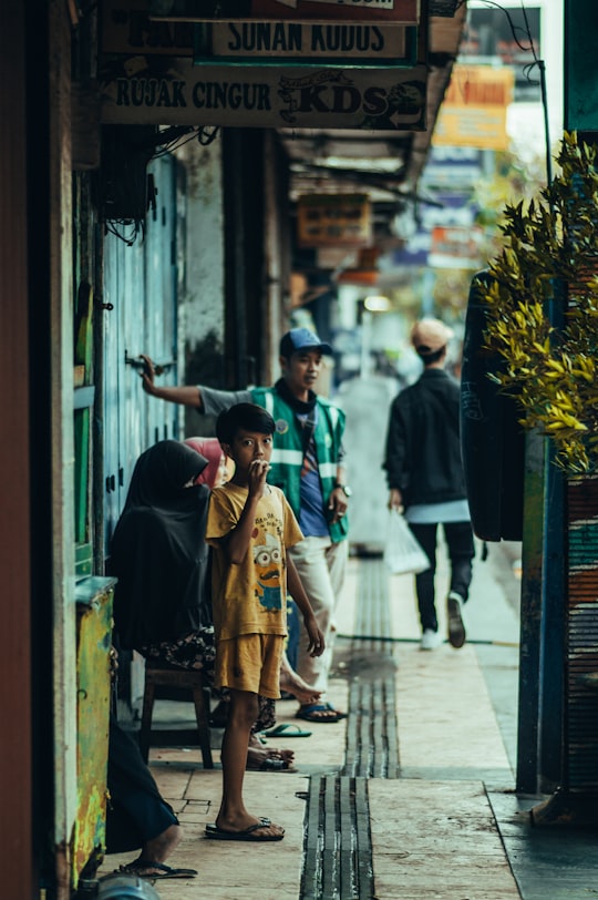 woman in yellow dress standing near man in green shirt in Malang Indonesia