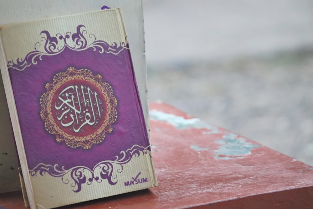 purple and gold book on brown wooden table