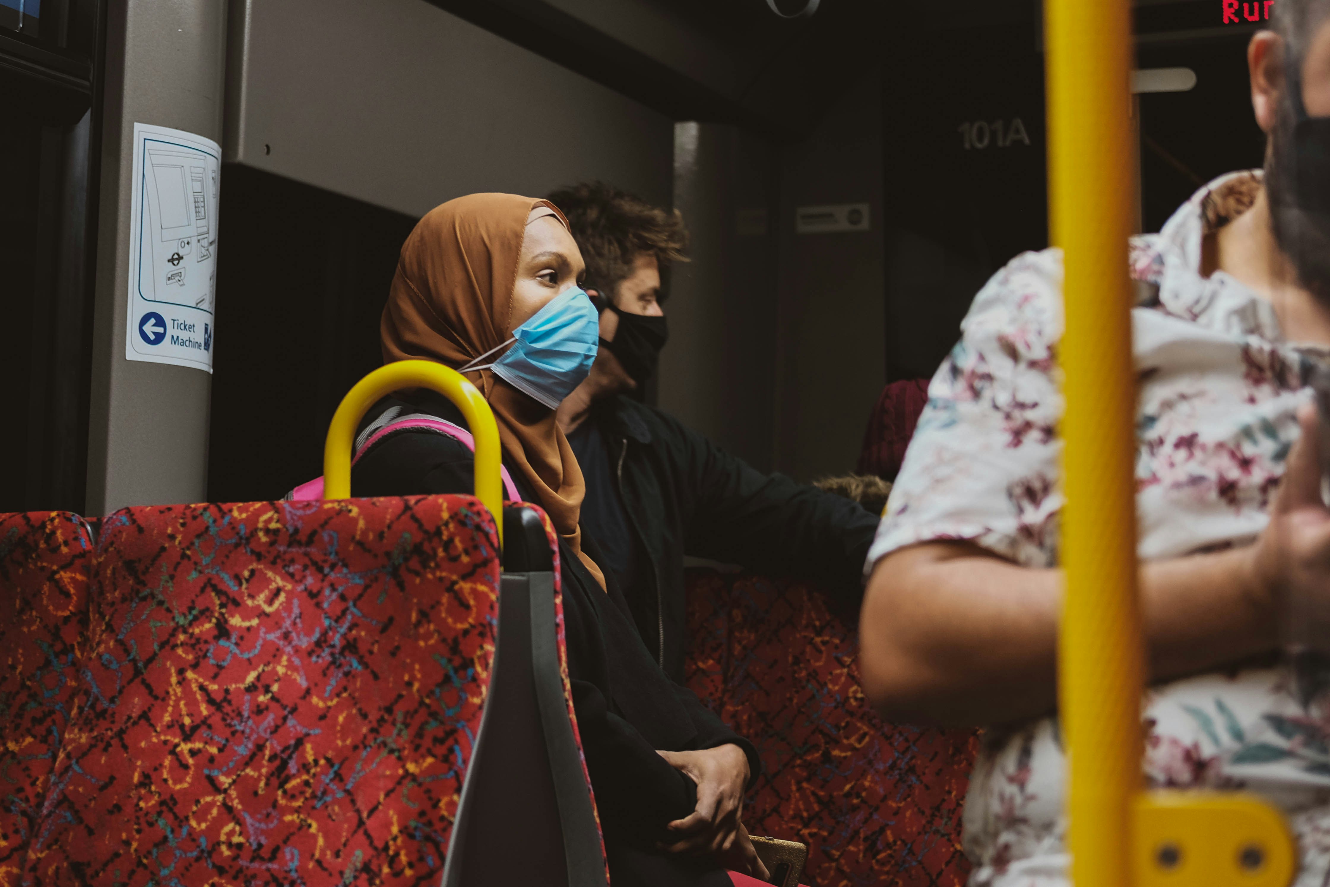 Passengers in masks seated on a city bus