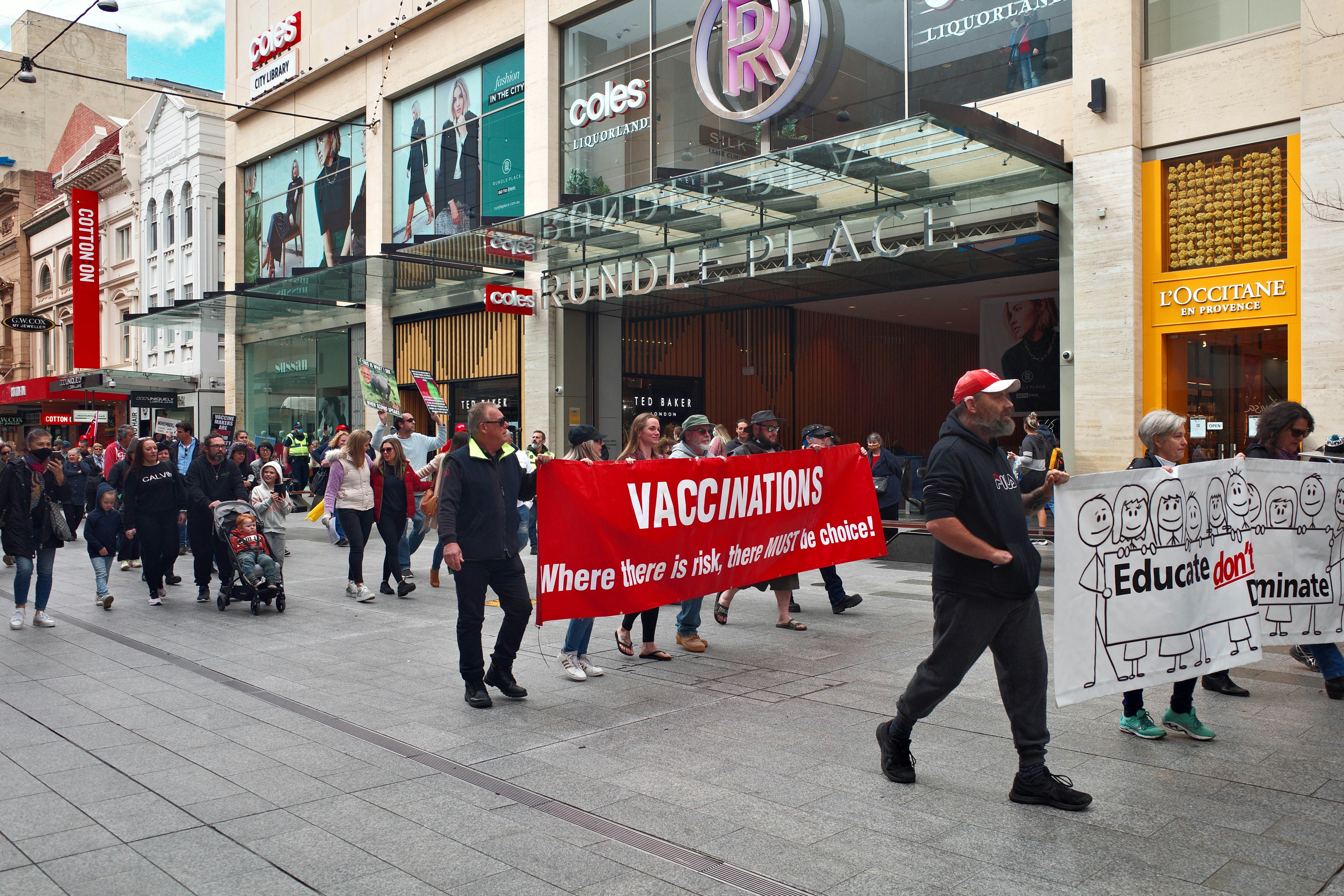 people holding red and white banner