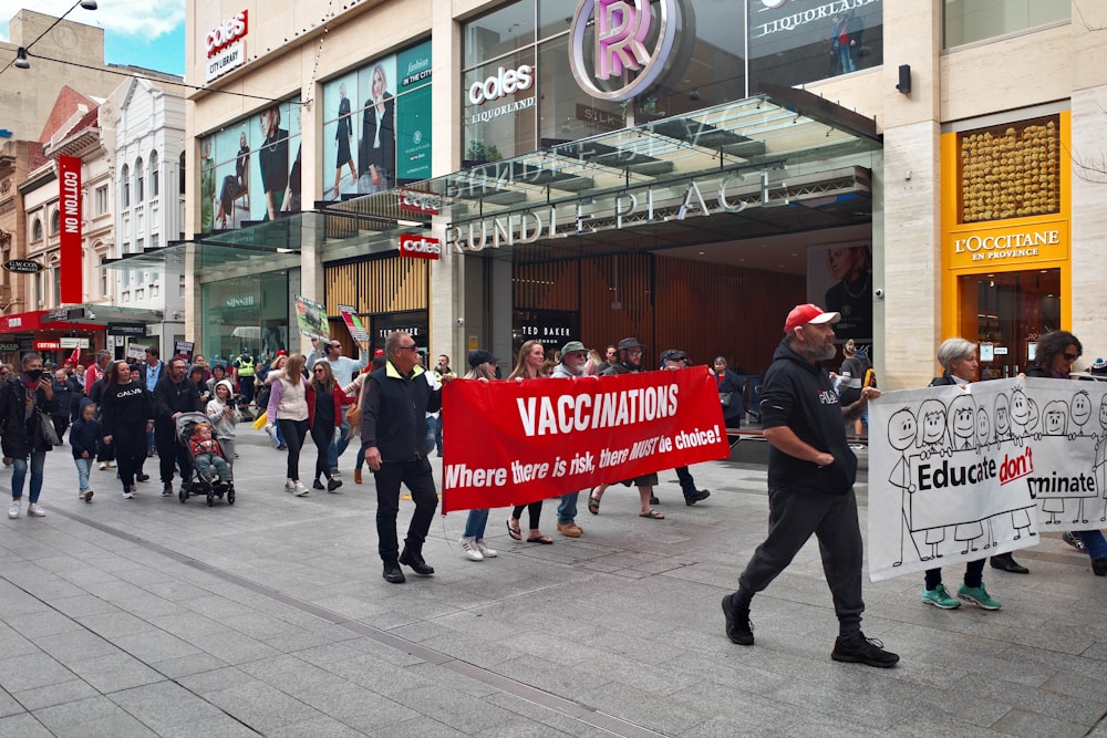 people holding red and white banner