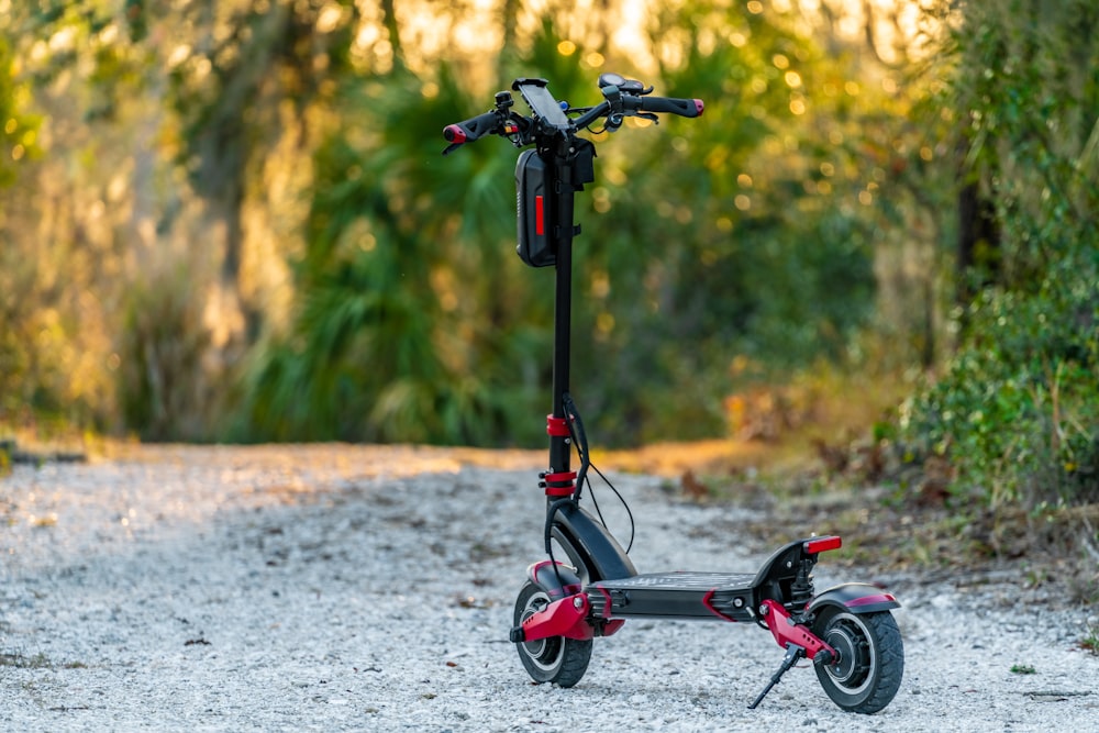 red and black bicycle with training wheels on gray concrete road during daytime