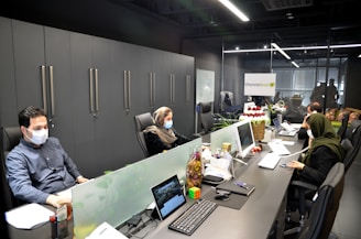 man in black jacket sitting on black office rolling chair