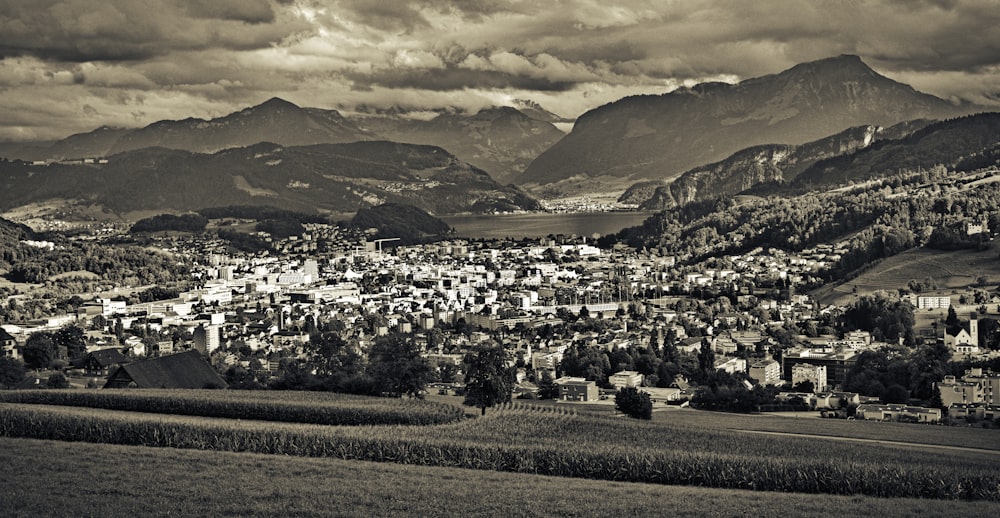 houses on green grass field near mountains under cloudy sky during daytime