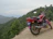 Motorcycle parked on a mountain trail with expansive forest views