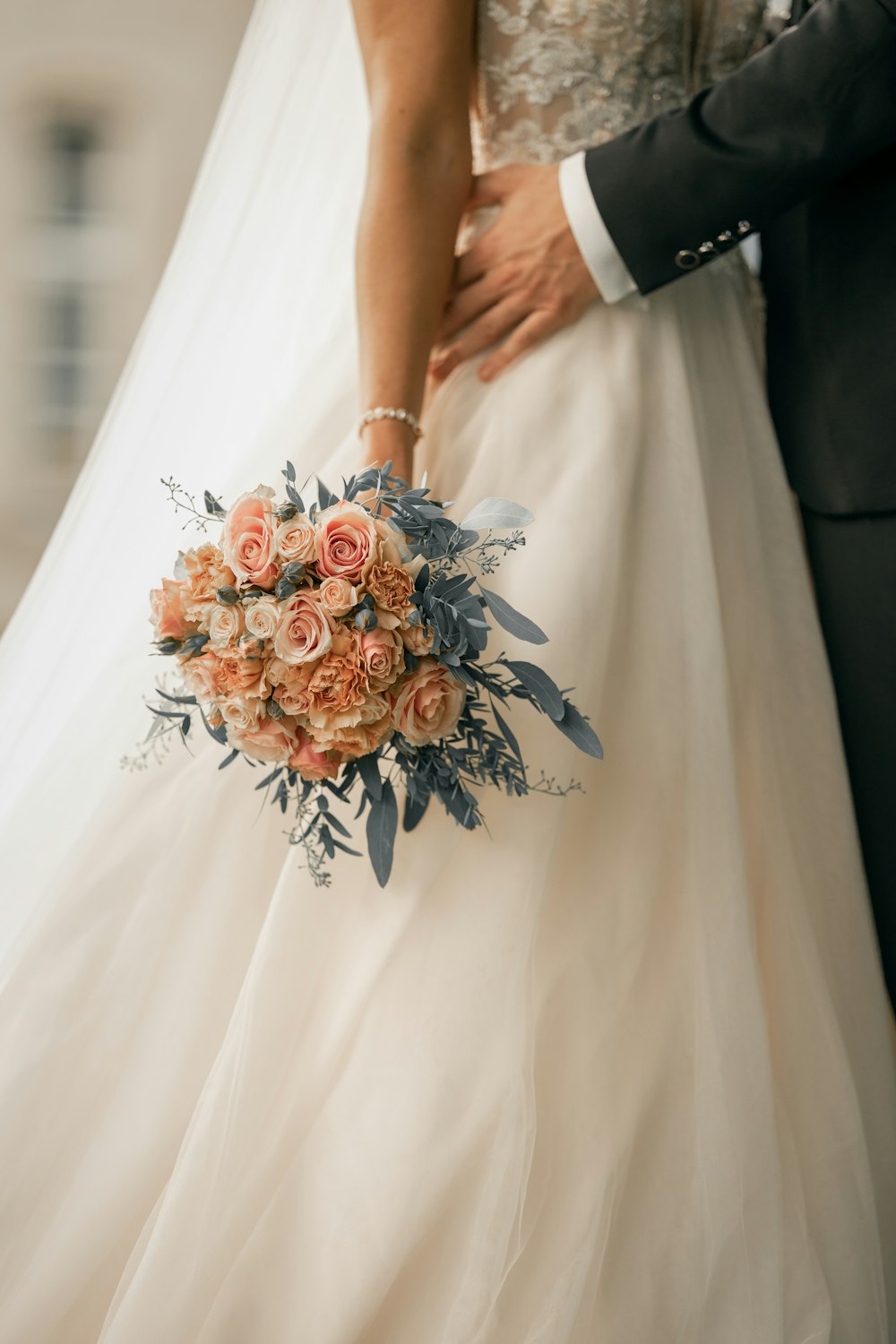 Frau im weißen Brautkleid mit Blumenstrauß