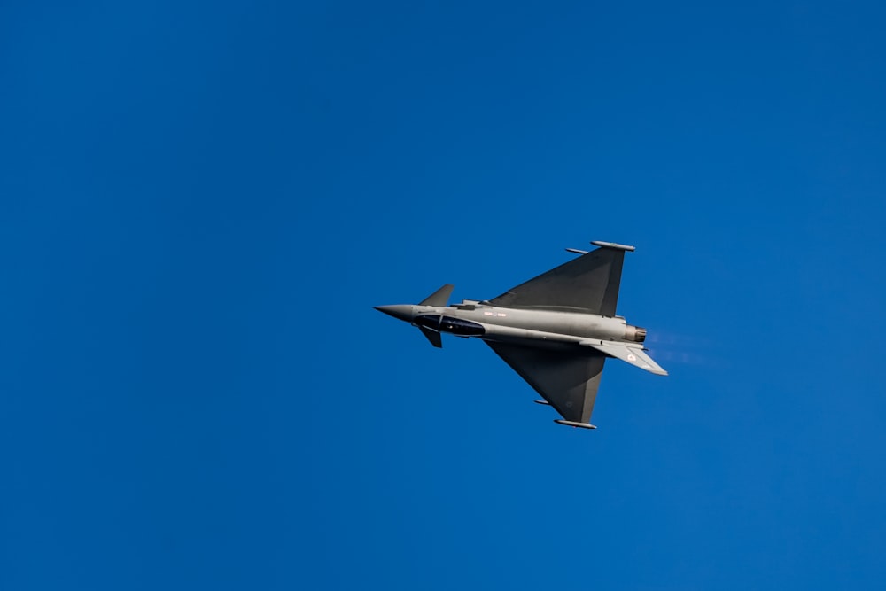 gray jet plane in mid air during daytime