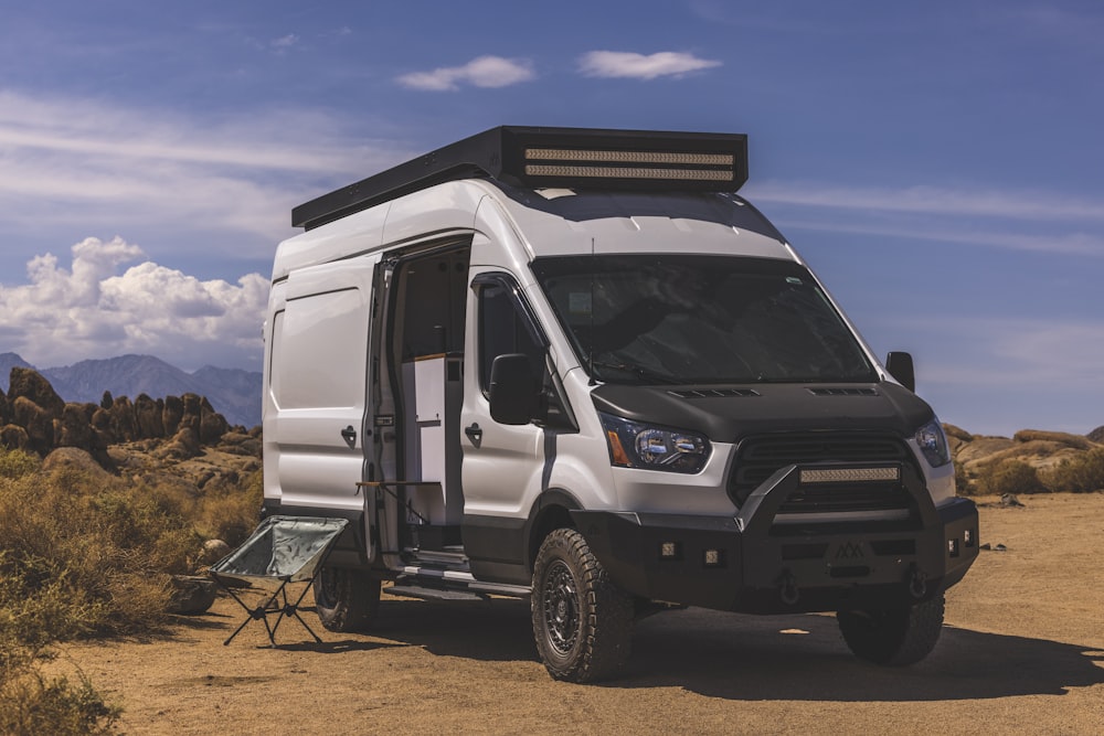 white and black van on brown soil during daytime