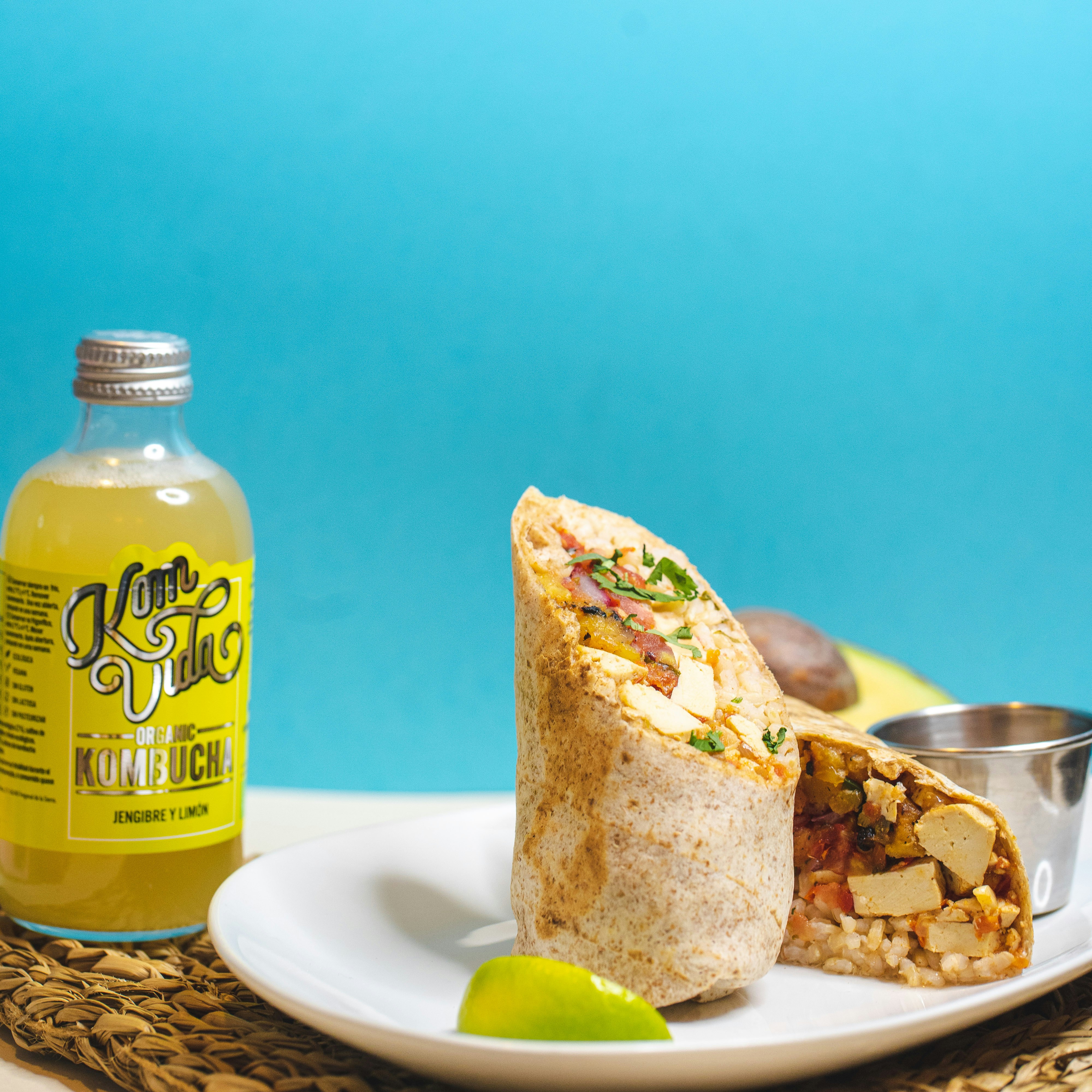 yellow and blue labeled bottle beside bread on white ceramic plate