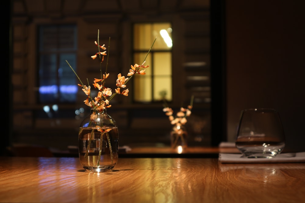 white flowers in clear glass vase on brown wooden table