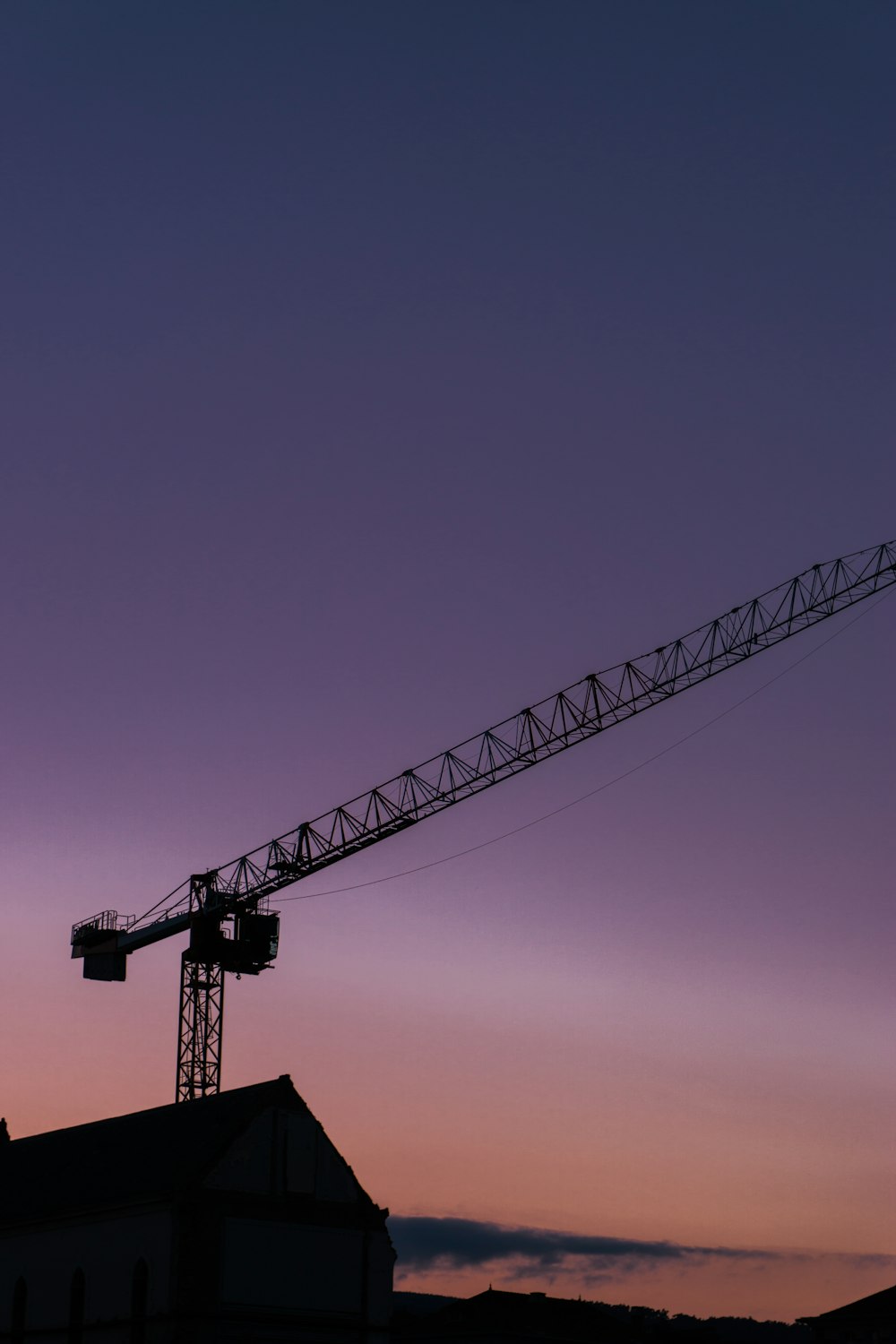 silhouette of crane under blue sky during daytime