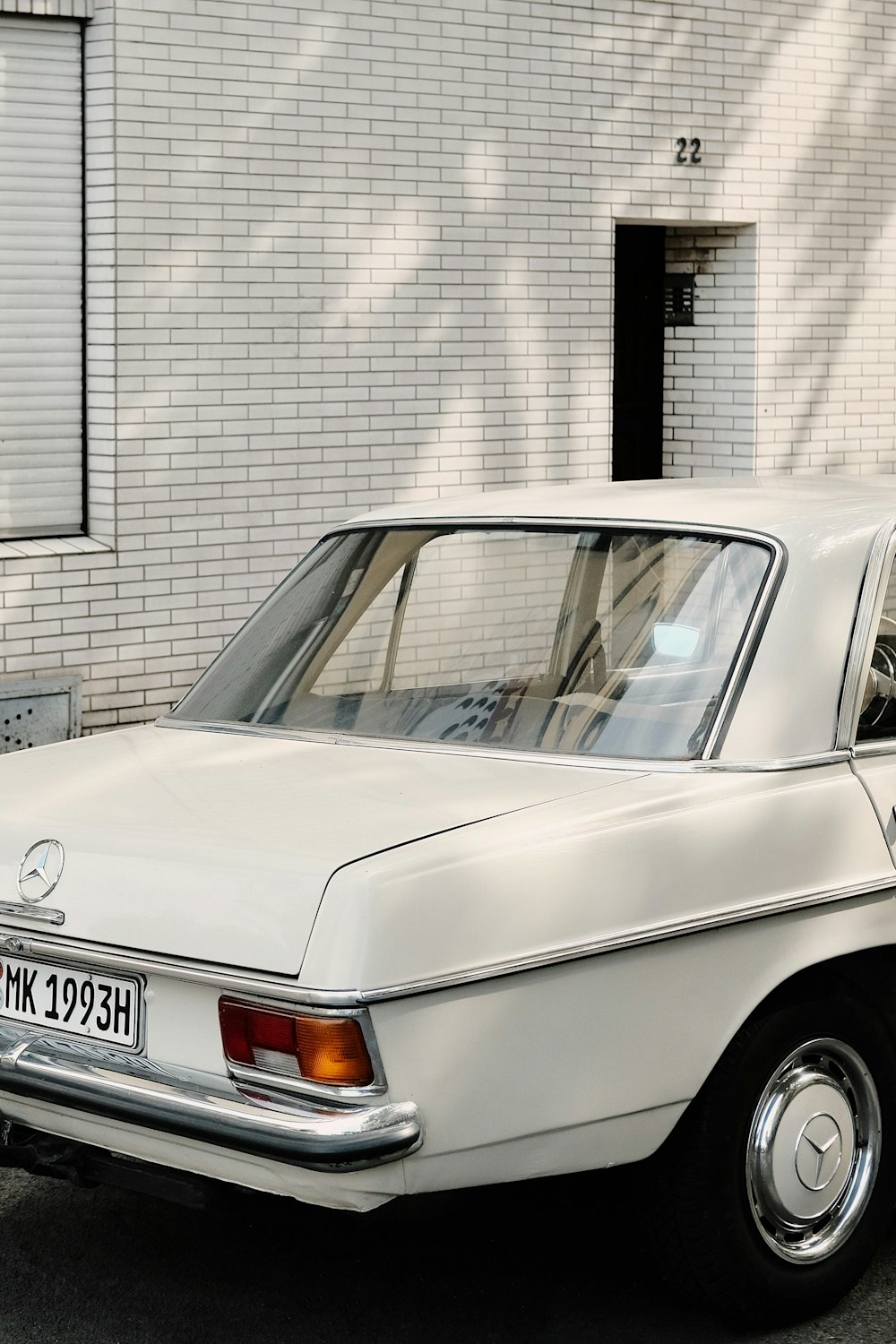 white mercedes benz coupe parked beside gray concrete building