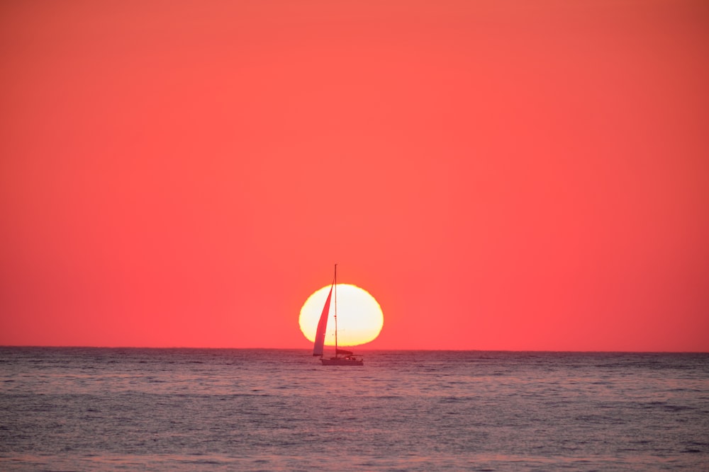 sailboat on sea during sunset