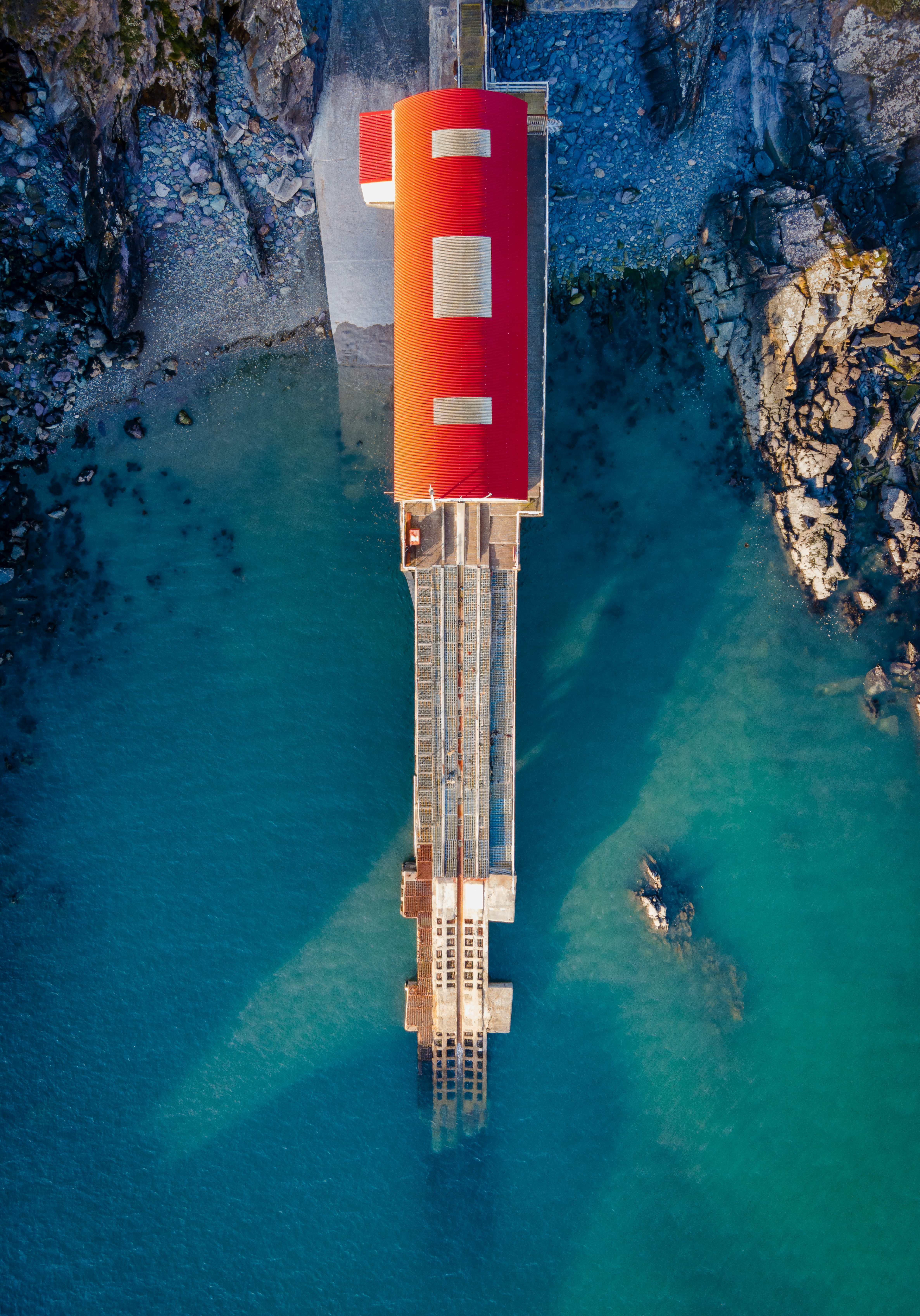 red and white tower near body of water during daytime