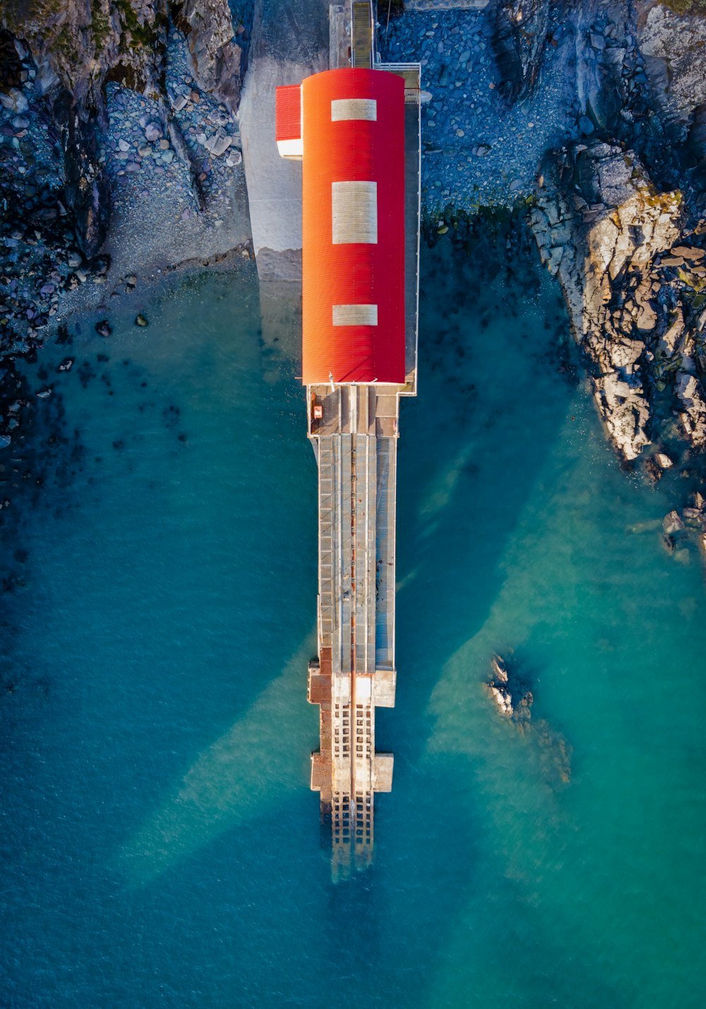 낮 동안 수역 근처의 빨간색과 흰색 타워