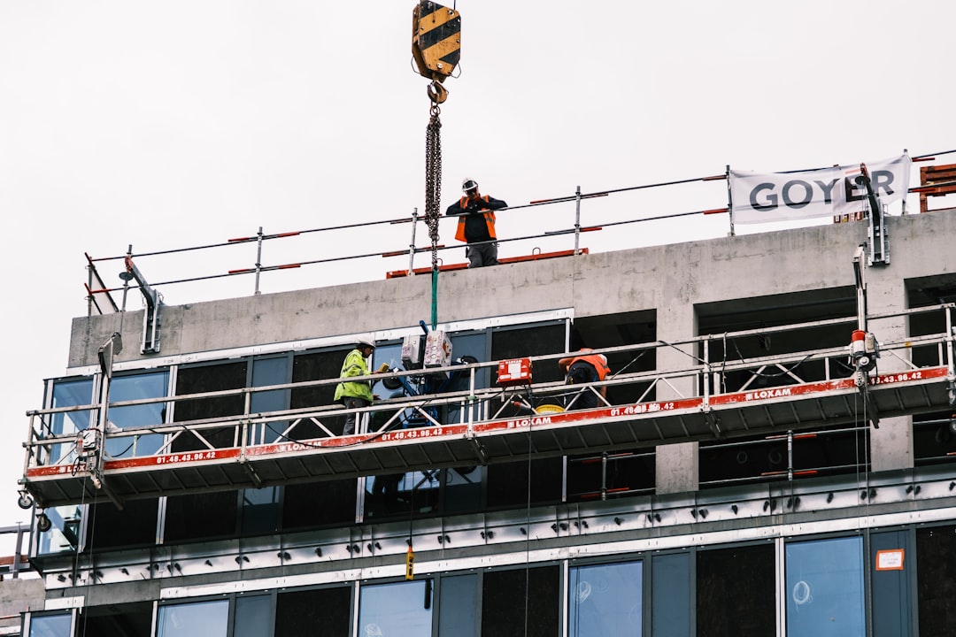 man in black jacket and black pants standing on top of building during daytime