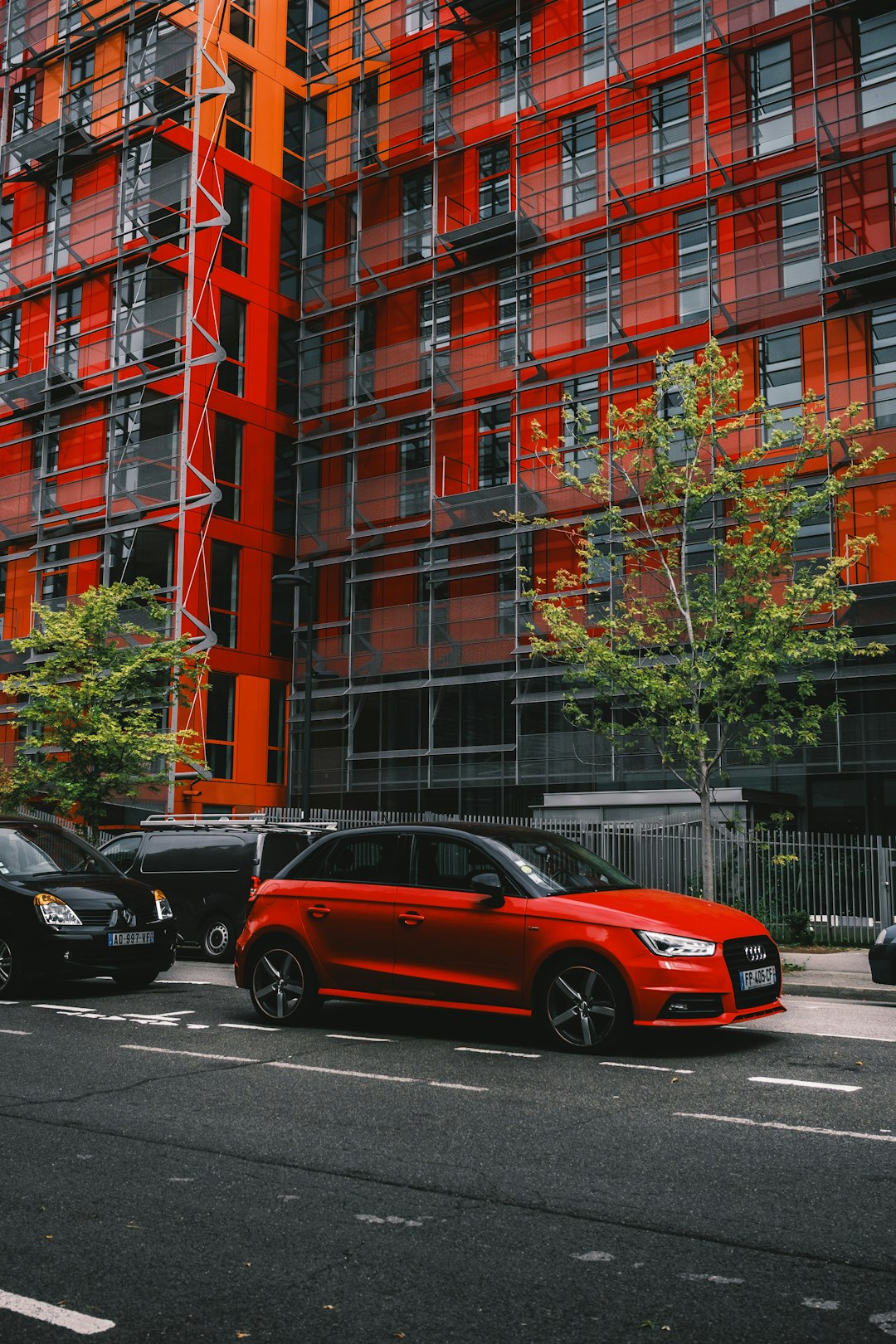 red sedan parked beside black car