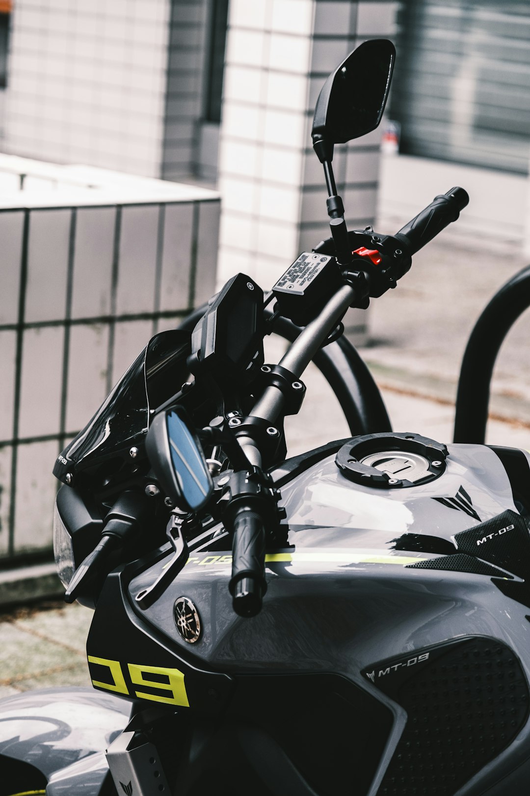 black and gray motorcycle parked beside white metal fence