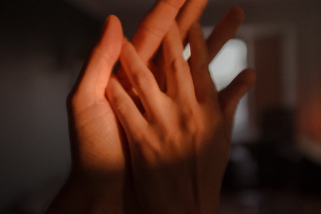 persons left hand on dark room