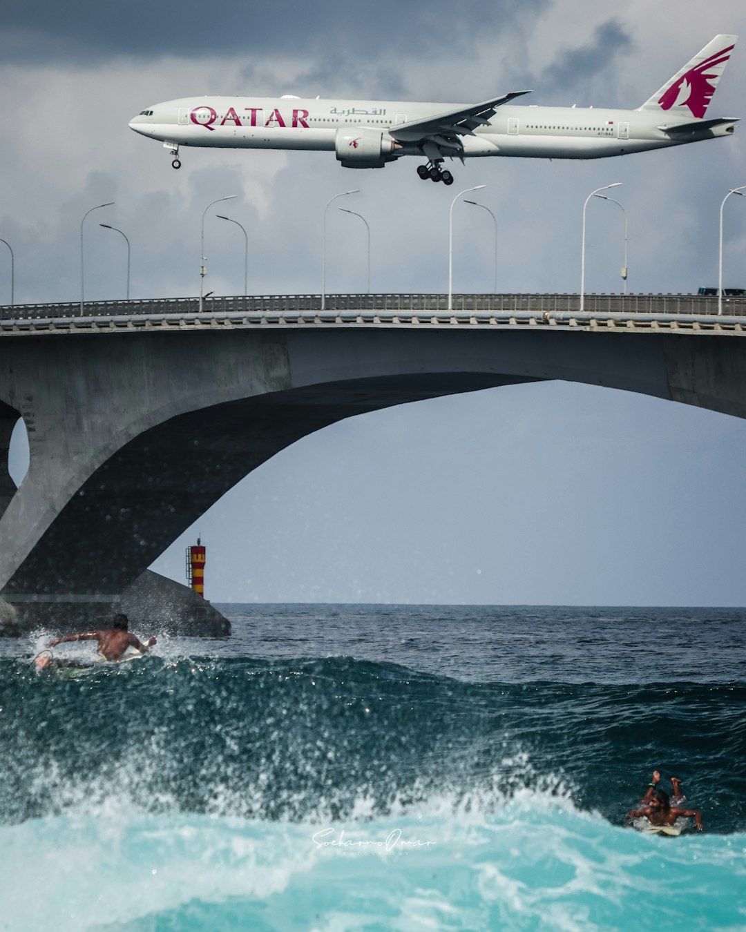 people riding on white and red plane on gray concrete bridge during daytime