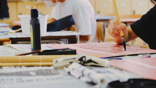 person holding pen writing on white paper