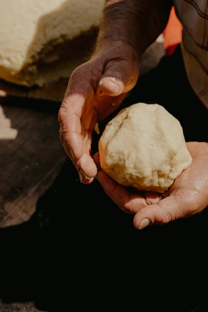 Close-up of hands shaping adobe bricks under the warm sunlight