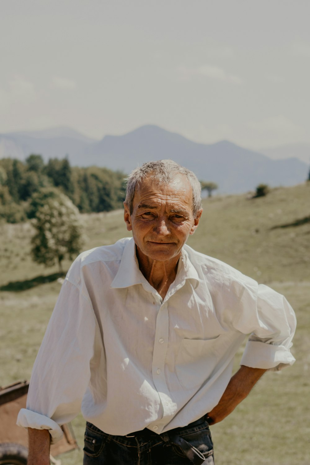 man in white button up shirt standing on brown field during daytime