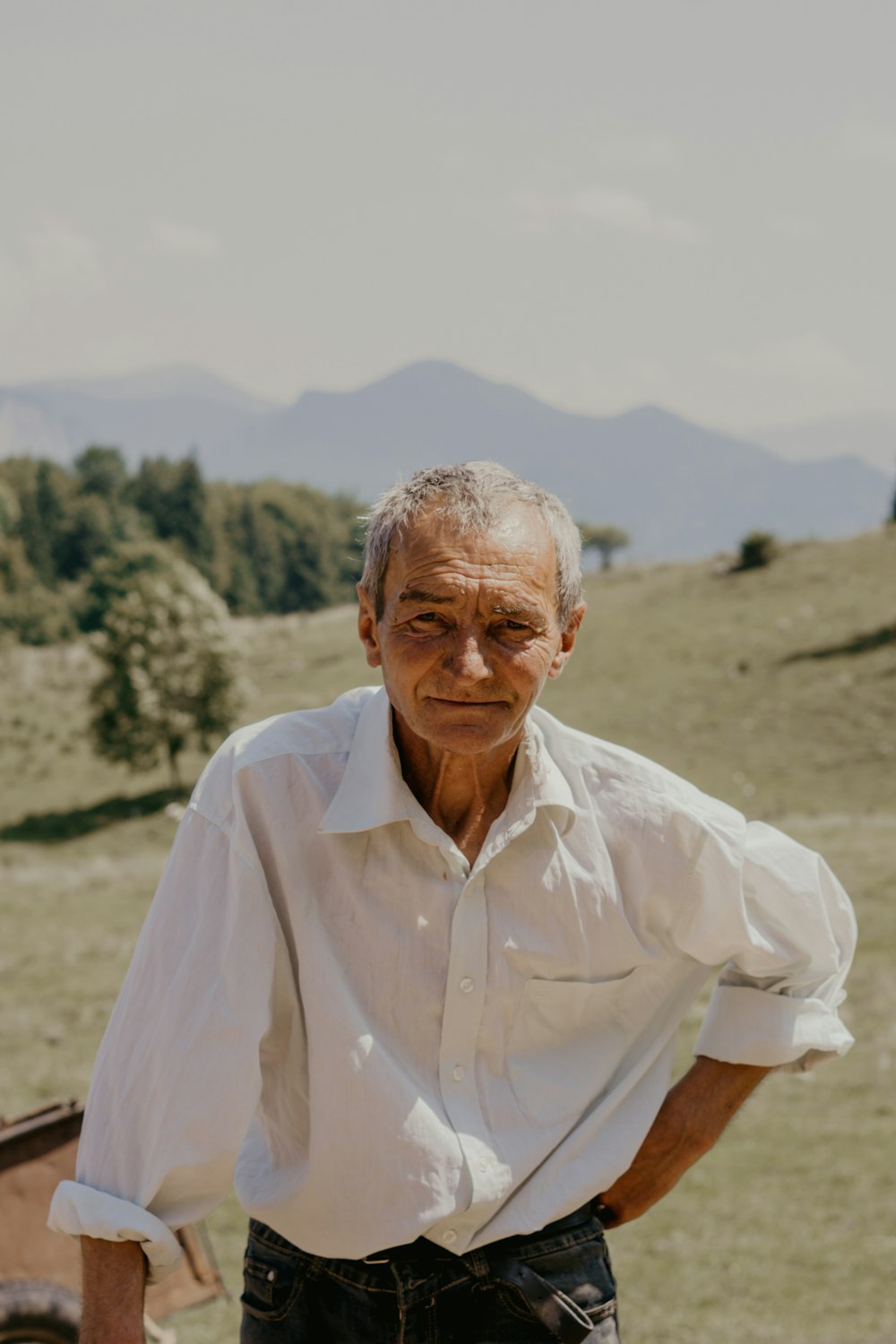 Mann in weißem Hemd steht tagsüber auf braunem Feld