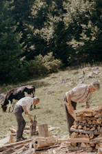 man in brown shirt and gray pants holding brown wooden stick