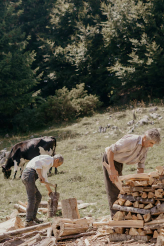 man in brown shirt and gray pants holding brown wooden stick