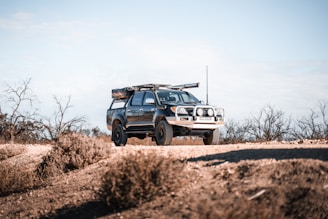 white and black jeep wrangler on brown field during daytime