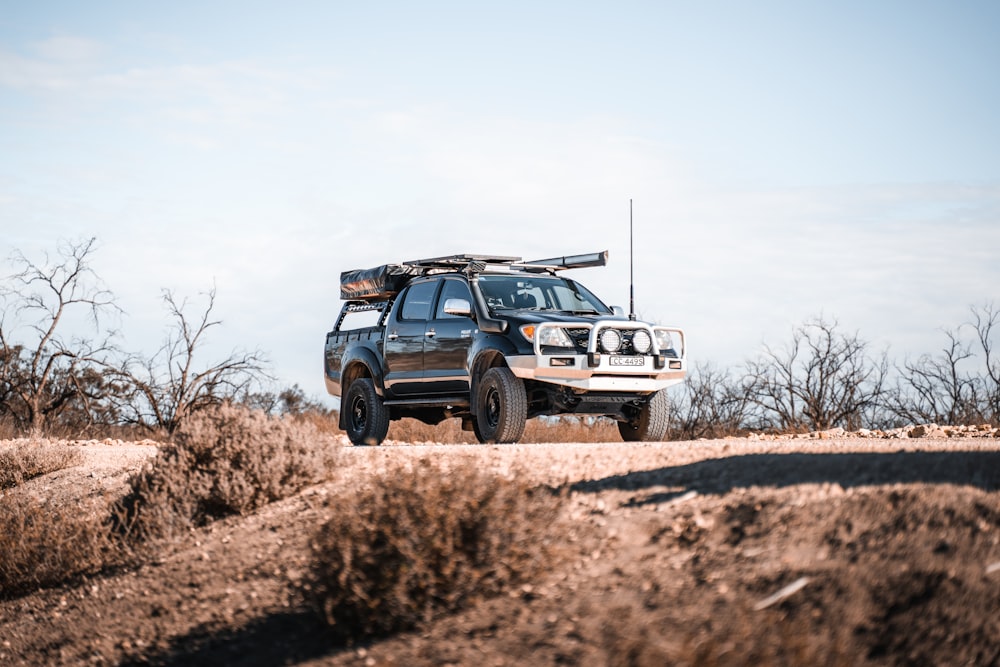 white and black jeep wrangler on brown field during daytime